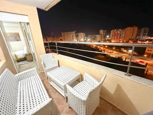 a balcony with chairs and a view of a city at LovelyStay - Luxury & proximity to Corniche and TGV in Tangier