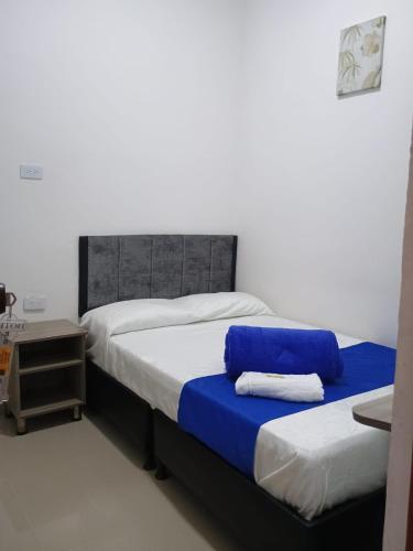 a bedroom with two beds with blue and white sheets at Hotel Cafe Estrella in Armenia