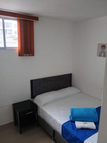 a small bedroom with two beds and a window at Hotel Cafe Estrella in Armenia