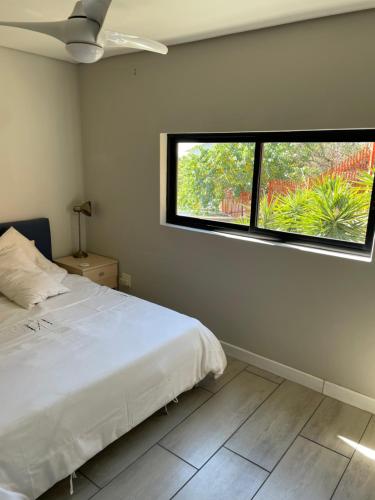 a bedroom with a white bed and a window at 2 Bedroom Urban Bliss in Windhoek