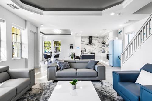 a living room with two couches and a kitchen at Chic & Cozy River District Townhouse in Fort Myers