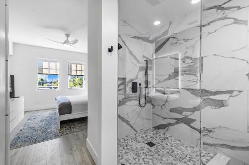 a bathroom with a shower with a marble wall at Chic & Cozy River District Townhouse in Fort Myers