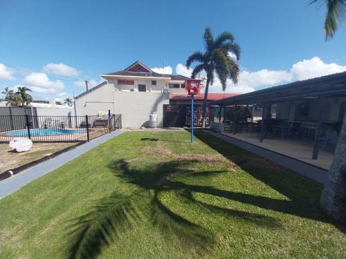 a shadow of a palm tree on the grass at Tropic Coast Motel in Mackay