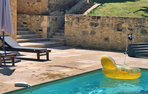 un objet en caoutchouc jaune dans l'eau d'une piscine dans l'établissement Le Domaine Du Cap La Roussie, à Saint-Cirq