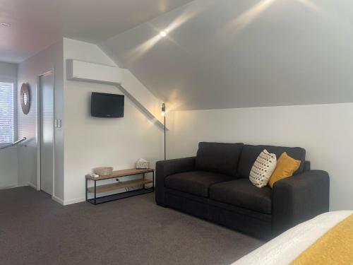 a living room with a couch and a tv at STUDIO42 in Papakura