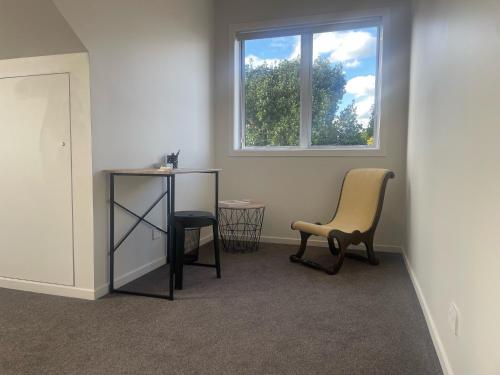 a room with a chair and a table and a window at STUDIO42 in Papakura