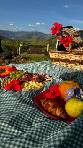 a table with plates of food on a checkered table cloth at Chalé Magia do Serrano in São Bento do Sapucaí