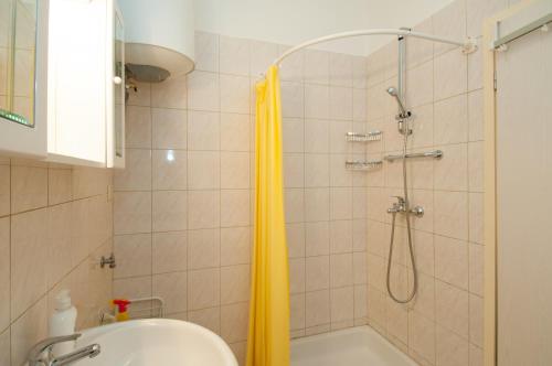 a bathroom with a shower with a yellow shower curtain at Apartment Villa Minach in Volosko