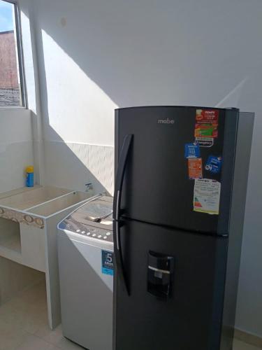 a black refrigerator in a kitchen next to a counter at Hotel Cafe Estrella in Armenia