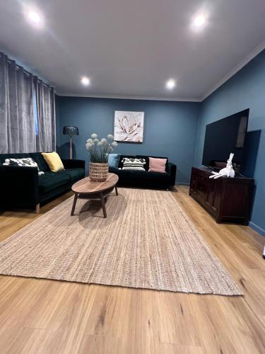 a living room with a couch and a table at Morisset Cottage Blackheath in Blackheath