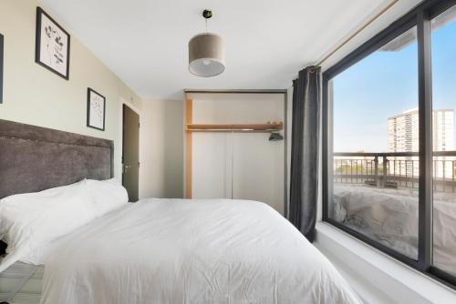 a bedroom with a white bed and a large window at Penthouse w/ Hot Tub near Stratford, Westfield in London
