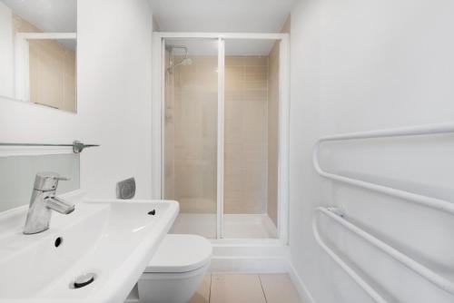 a white bathroom with a toilet and a sink at Penthouse w/ Hot Tub near Stratford, Westfield in London