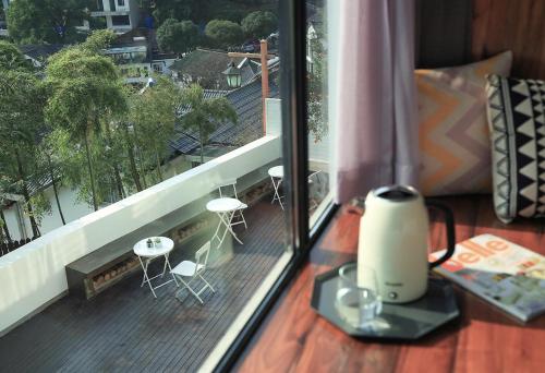 a balcony with a view of a deck with tables and chairs at Hangzhou Spring B&B in Hangzhou