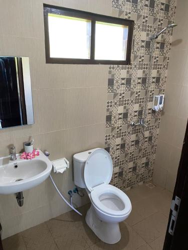 a bathroom with a toilet and a sink at Q'Pelagos Sunset Bungalow in Gili Trawangan