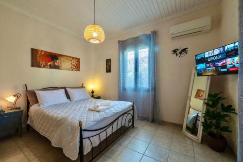 FaraíにあるKaterinas Houseのベッドとテレビのある寝室
