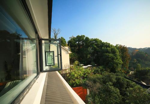a balcony of a house with a view of trees at Hangzhou Spring B&B in Hangzhou