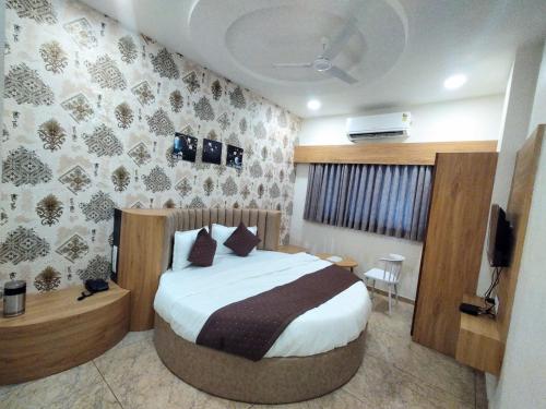 a hotel room with a bed and a television at Hotel Lee Pride in Anand