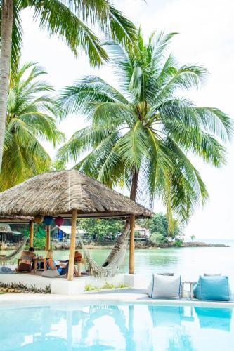 a resort with a swimming pool and palm trees at Orion Healing Centre in Srithanu