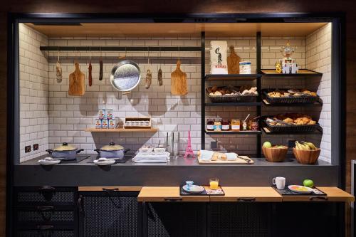 a bakery with a counter with food on it at Moxy Paris Charles de Gaulle Airport in Roissy-en-France