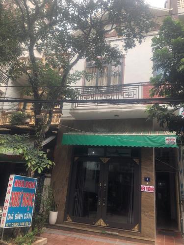 una entrada a un edificio con toldo verde en Nhà nghỉ Như Ngọc en Diện Biên Phủ