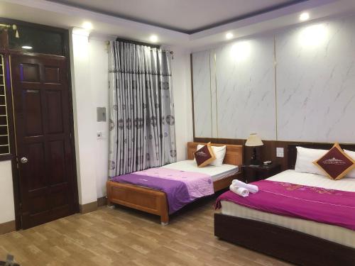 een slaapkamer met 2 bedden met paarse en witte lakens bij Nhà nghỉ Như Ngọc in Diện Biên Phủ