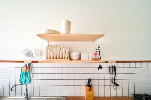 a kitchen with a shelf with plates and utensils at Also pool villa in Wangkata