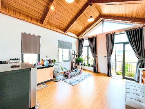 a large living room with wooden ceilings and windows at Moon Homestay TWO in Xuan An