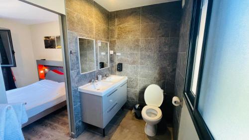 uma casa de banho com um lavatório, um WC e um chuveiro em La Villa Kazuera em Cilaos