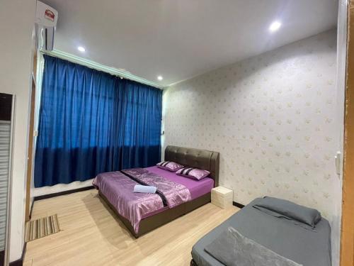 1 dormitorio con cama morada y ventana en Lisa Homestay Sandakan, en Sandakan
