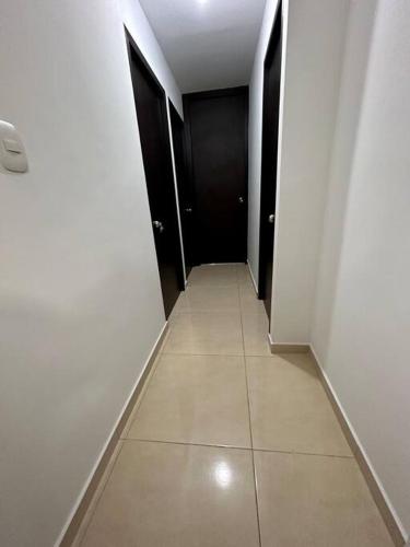 a hallway with two black doors and a tile floor at Lindo apartamento de 3 habitaciones in Cúcuta