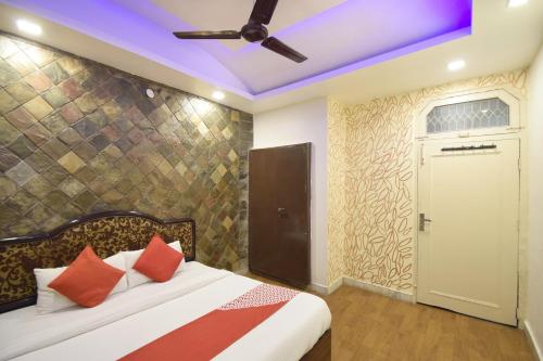 Super OYO Hotel Maa Residency في جامو: غرفة نوم مع سرير ومروحة سقف