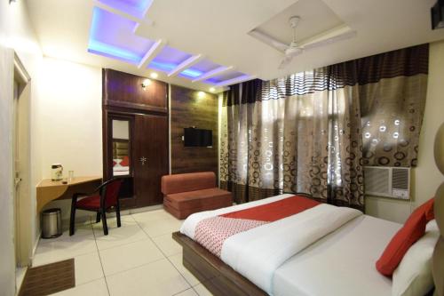 a bedroom with a bed and a desk and a chair at Super Hotel O Maa Residency in Jammu