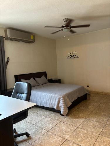 1 dormitorio con 1 cama y ventilador de techo en Habitación Roble en Saltillo