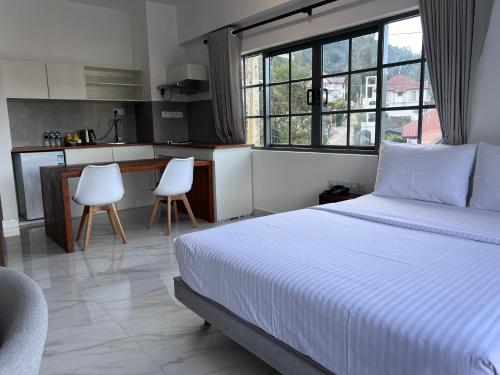 a bedroom with a white bed and a kitchen at 88th Nuwara Eliya in Nuwara Eliya