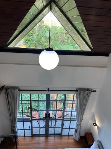 an attic room with a large window and a light fixture at 88th Nuwara Eliya in Nuwara Eliya