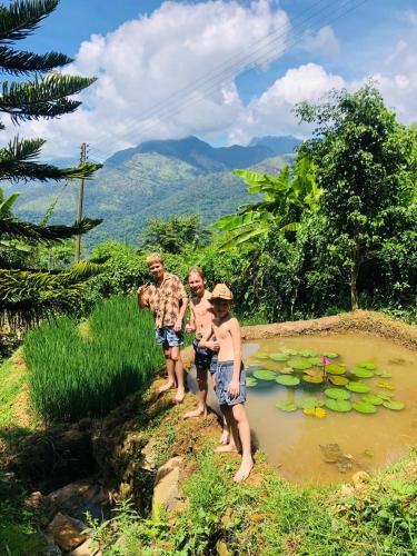 a group of people standing in a pond with lilies at Awesome Place in Ella