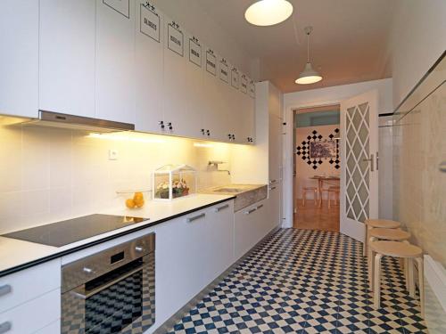 uma cozinha com armários brancos e um piso xadrez em Uporto House Villa no Porto