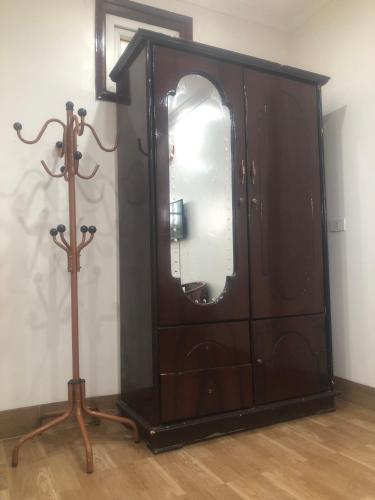 a wooden dresser with a mirror in a room at Nhà nghỉ Như Ngọc in Diện Biên Phủ