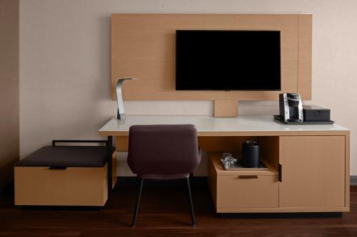 a room with a desk with a chair and a tv at Des Moines Marriott Downtown in Des Moines