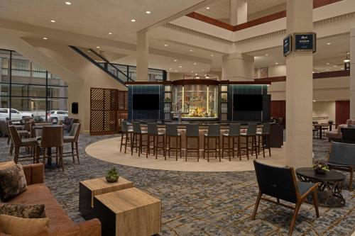 a lobby with a bar with chairs and tables at Des Moines Marriott Downtown in Des Moines