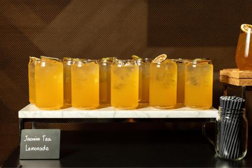 a row of glasses of orange juice on a shelf at Delta Hotels by Marriott Edmonton Centre Suites in Edmonton