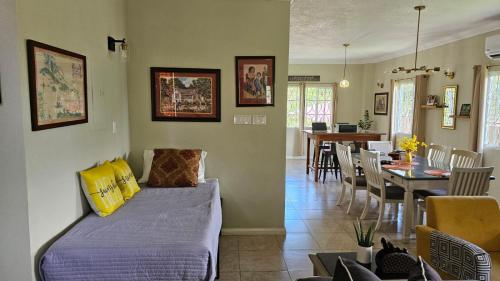 a living room with a bed and a dining room at Komfort Getaway Villa in Ocho Rios