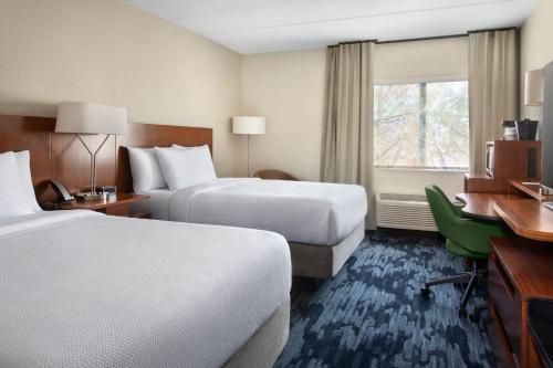 a hotel room with two beds and a desk at Fairfield by Marriott Inn & Suites Wallingford New Haven in Wallingford