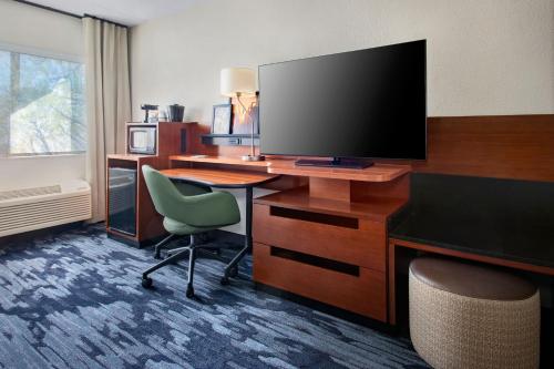 a hotel room with a desk with a television and a chair at Fairfield by Marriott Inn & Suites Wallingford New Haven in Wallingford
