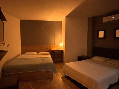um quarto com 2 camas e uma mesa com um candeeiro em Daniel Apartment em Guayaquil