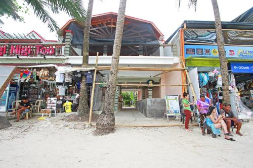 un gruppo di persone seduti sulle sedie di fronte a un negozio di Nigi Nigi Too Beach Resort a Boracay