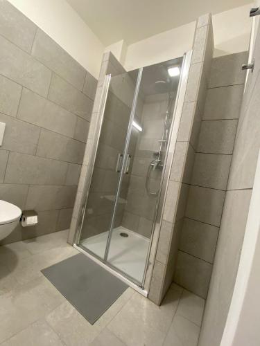 a shower with a glass door in a bathroom at MINATO Apartments Ostrava center in Ostrava