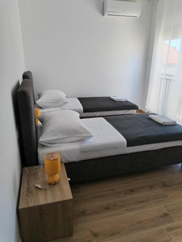 a bedroom with two beds and a wooden table at Adriatica in Zadar