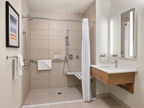 een badkamer met een wastafel en een douche bij Staybridge Suites Minneapolis-Maple Grove, an IHG Hotel in Maple Grove