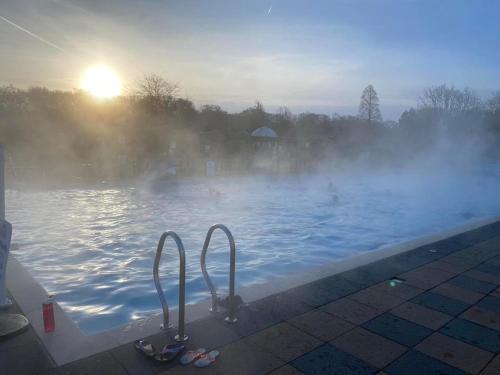 a swimming pool with mist in the water at Lakewood retreat in Woodhall Spa